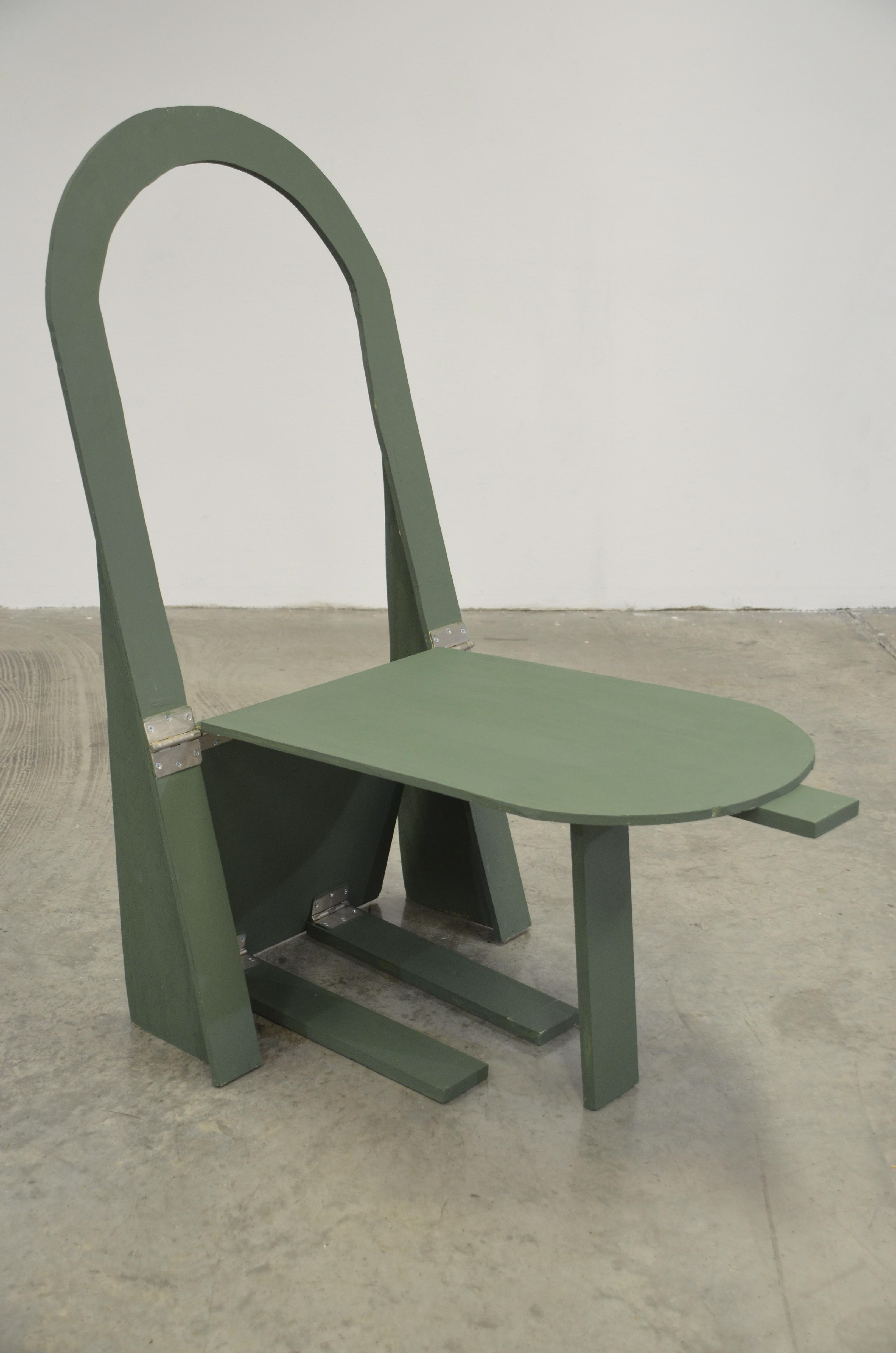 Image ID: A photo of green chair made of wood with a circular open back, with a stand below supporting the seat.